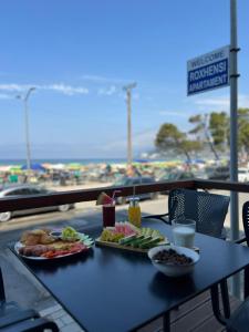Una mesa con dos platos de comida encima. en Roxhensi, en Shëngjin
