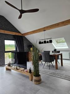 un soggiorno con TV e tavolo da pranzo di Idyllic Loft Kumani Ago - Villa Rizas Hills a Traben-Trarbach