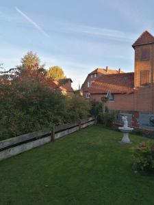 a backyard with a fence and a fountain in the grass at GARNI in Hemmingen