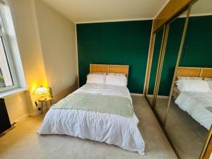 a bedroom with two beds and a large mirror at Stylish 2-Bedroom Modern Flat in Dundee