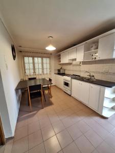 a kitchen with white cabinets and a table in it at Casa centrica en San rafael mendoza in San Rafael