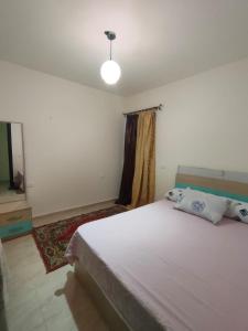 a bedroom with a large bed and a television at شالية في قرية جراند هيلز in Dawwār ‘Abd Allāh