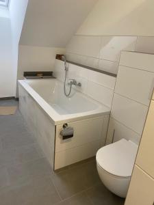 a bathroom with a toilet and a bath tub at Hengstresort Velten in Velten +18 photos