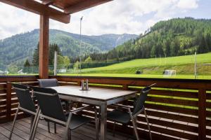 a table and chairs on a deck with a view of a mountain at Triebenstein Hideaway in Hohentauern
