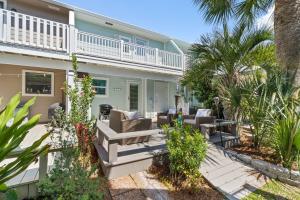 a home with a patio with chairs and palm trees at 140 Feet To White Sandy Beaches! Newly Renovated! Pool! Grill! in Laguna Beach