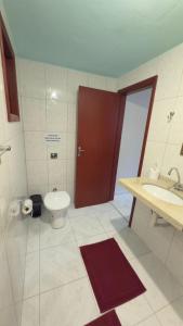 a bathroom with a toilet and a sink and a door at Chalés Recanto das Rosas in Monte Verde +15 photos