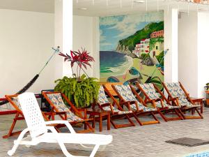 - une rangée de chaises dans une pièce ornée d'une fresque murale dans l'établissement Hostal Laurita Beach, à Montañita
