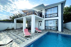 a house with two chairs and a swimming pool at White Terrace Villa in Gabala