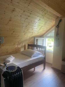 a bedroom with a bed and a wooden ceiling at Riza Guest House in Pukë