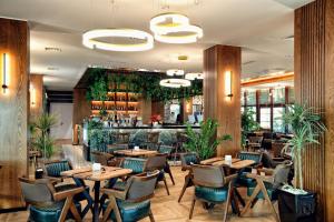 a restaurant with tables and chairs and a bar at Meridian Luxury Apartments in Shkodër
