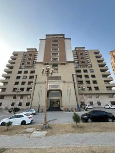 a large building with cars parked in front of it at 2-BHK Stay Minutes from the Airport & Motorway in Islamabad