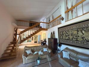 a living room with two couches and a staircase at Villa les Faou-Anis in Le Castellet