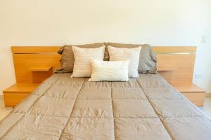 a bed with a brown comforter and several pillows at Punta Piedra By Andiani in Cancún