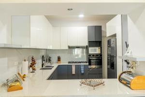 a large kitchen with white cabinets and appliances at Punta Piedra By Andiani in Cancún