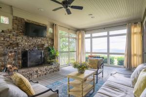 a living room with a stone fireplace and a tv at French Quarter - New Orleans Charm in the Mountain in Mentone