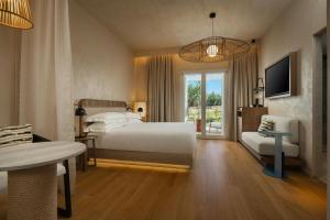 a bedroom with a bed and a television and a table at Cala Ponte, a Tribute Portfolio Hotel in Polignano a Mare +37 photos