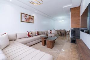 a living room with a couch and a fireplace at Appartement avec Piscine dans Résidence Privée in Dar Bouazza