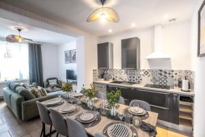 una cucina e un soggiorno con tavoli e sedie di La Villa des Oliviers - Les Demeures d 'Adrien a Valenciennes