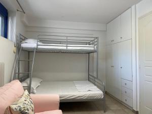a room with two bunk beds and a couch at Maisonette by the sea in Melission