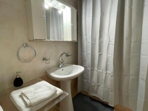 a bathroom with a sink and a shower curtain at Maisonette by the sea in Melission +21 photos