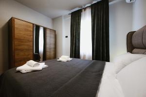 a bedroom with a bed with two towels on it at Siel simple elegance Volos in Volos