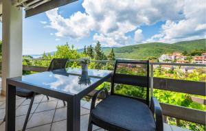 a table and chairs on a balcony with a view at 1 Bedroom Beautiful Apartment In Rabac in Rabac