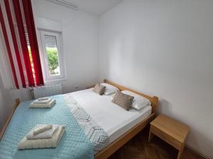 ein Schlafzimmer mit einem Bett, auf dem zwei Handtücher liegen in der Unterkunft Apartments Antonio in Baška