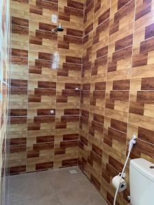 a bathroom with a shower with wooden tiles at Pousada Garrida in Itarema +10 photos