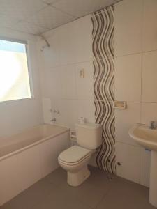 a bathroom with a toilet and a tub and a sink at Casa Bella in Potosí
