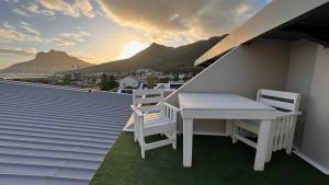 a table and two chairs on a balcony with a view at Beachview Apartment in Hout Bay