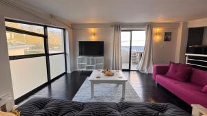 a living room with a pink couch and a table at Beachview Apartment in Hout Bay