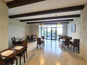a dining room with wooden tables and chairs at Hotel Ere's Palace in Tbilisi City
