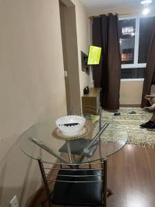 a glass table with a bowl on it in a living room at Apto 2 qts em Xerém próximo ao CT do Fluminense in Duque de Caxias