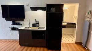 eine Küche mit einem schwarzen Kühlschrank und einer Spüle in der Unterkunft Studio 6 Beaumont, TX in Beaumont