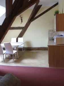 a dining room with a table and white chairs at Penzion Elzet in Třeboň