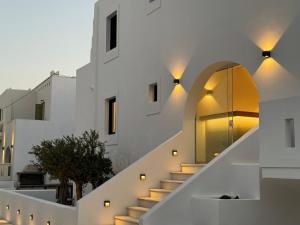 a house with white walls and stairs with lights at Olive Garden Hotel in Agios Prokopios