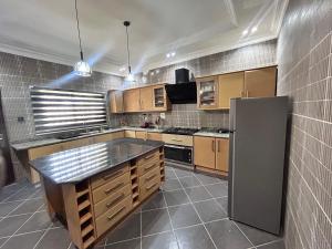 cocina grande con armarios de madera y nevera de acero inoxidable en Go flex homes, en Ikuata 16 fotos más