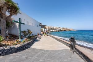 Una pasarela junto al océano con una cruz en ella. en El Poris, en Porís de Abona