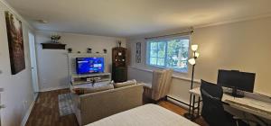a living room with a couch and a television at Executive Private Room in a Shared Apartment- Comfortable and Convenient in Saint John