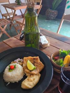ベレンにあるA Casa Jambu Mineiroのご飯と野菜とボトルが入った皿