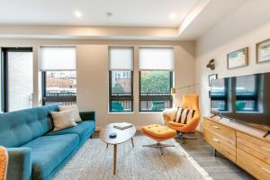 a living room with a blue couch and a tv at 2 Mi to Downtown Denver Modern Condo with Balcony! in Denver