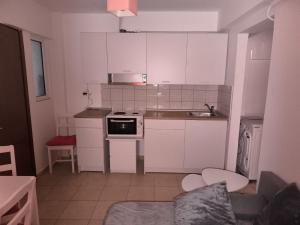 a small kitchen with white cabinets and a sink at Johanna's apartment in Preveza