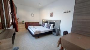 a bedroom with a bed and a couch in a room at Lindos Panorama in Líndos