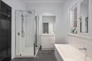 a bathroom with a shower and a tub and a sink at Bendigo Signature Accommodation Group Holiday in Bendigo +18 photos