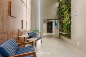 a hallway with chairs and tables and a plant wall at Building with New Apartments 300m from the Beach - EEP in Guarapari