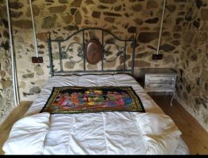 a bed in a room with a stone wall at La Casa de la Fuente 