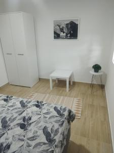 a white room with a bed and a table at Silverdrop apartmani Srebrno jezero in Veliko Gradište +16 photos