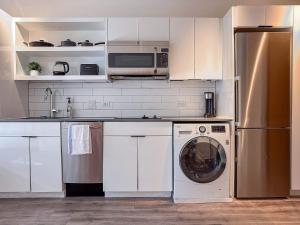 a kitchen with a washing machine and a microwave at City & River View Suite - The Wharf DC by Monthier in Washington +12 photos