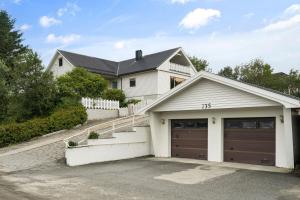 a white house with a garage at Lofoten Apartment 02 in Leknes