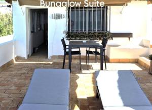 a patio with a table and a chair and a balcony at Mandala Bungalows - Adults Only in Los Caños de Meca
